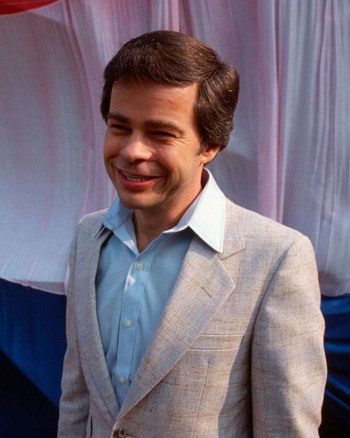 A young Jim Bakker, the famous televangelist, smiling in a light-colored suit jacket A young Jim Bakker, the famous televangelist, smiling in a light-colored suit jacket