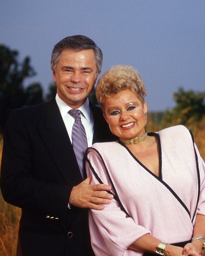 Televangelist Jim Bakker and Tammy Faye Bakker smiling together in a portrait outdoors. Televangelist Jim Bakker and Tammy Faye Bakker smiling together in a portrait outdoors.