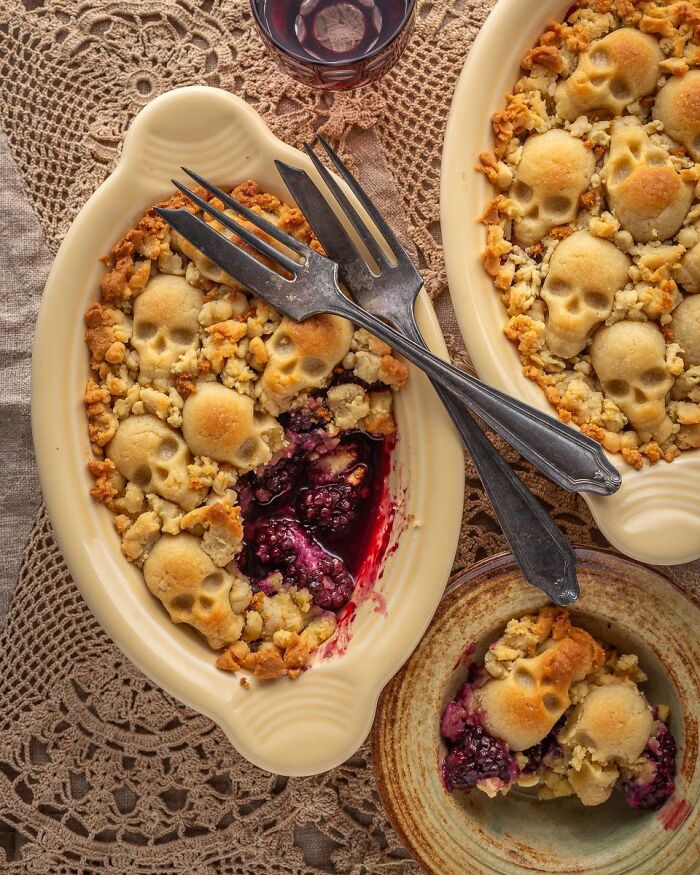 Freshly baked blackberry cobbler topped with skull-shaped pie crust dough for spooky Halloween foods ideas.