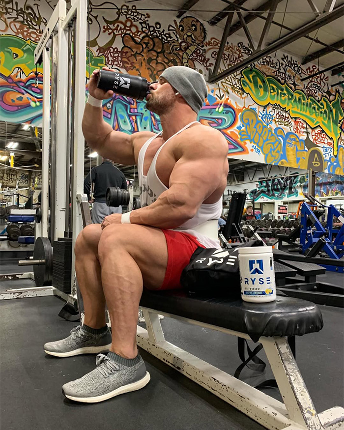 Bodybuilder Joey Swoll drinking from a shaker cup during a gym workout Bodybuilder Joey Swoll drinking from a shaker cup during a gym workout