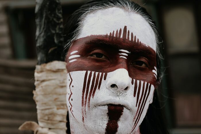 Close-up of a person with face paint, reflecting traditional spiritual practices found in lesser-known cults.
