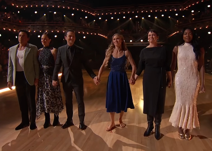 A Hollywood actress holding hands with cast members during a reality show tribute to a late co-star.