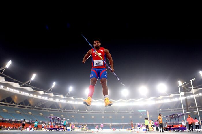 Athlete mid-air with javelin during night event at Siena International Photo Awards 2026