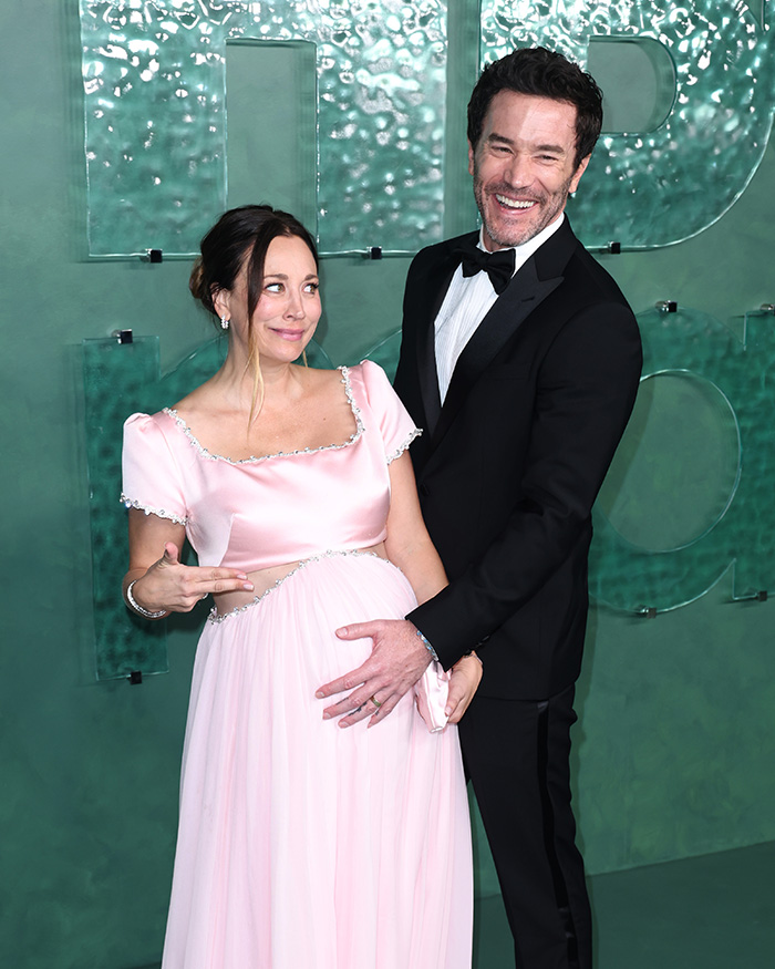 Pregnant woman in pink gown with man in tuxedo at event for celebrities secret contest Pregnant woman in pink gown with man in tuxedo at event for celebrities secret contest