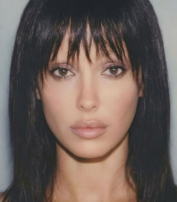 Close-up portrait of Bianca Censori featuring dark hair with bangs and pale makeup.