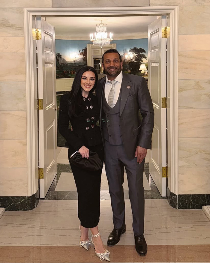 Kash Patel and his fianc&eacute;e dressed in formal wear standing in a doorway
