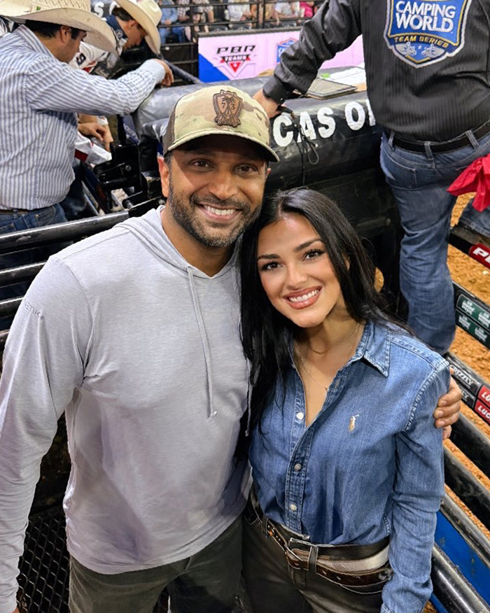 Kash Patel and his fianc&eacute;e smiling together outdoors in casual clothing