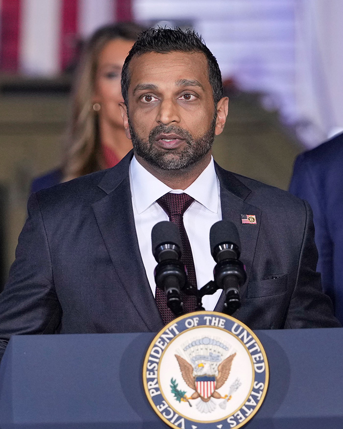 Kash Patel speaking at a podium with microphones, following news of his sudden engagement.