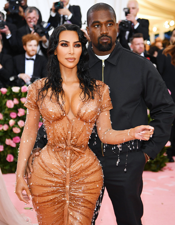 Kim Kardashian and Kanye West posing together at a red carpet event Kim Kardashian and Kanye West posing together at a red carpet event