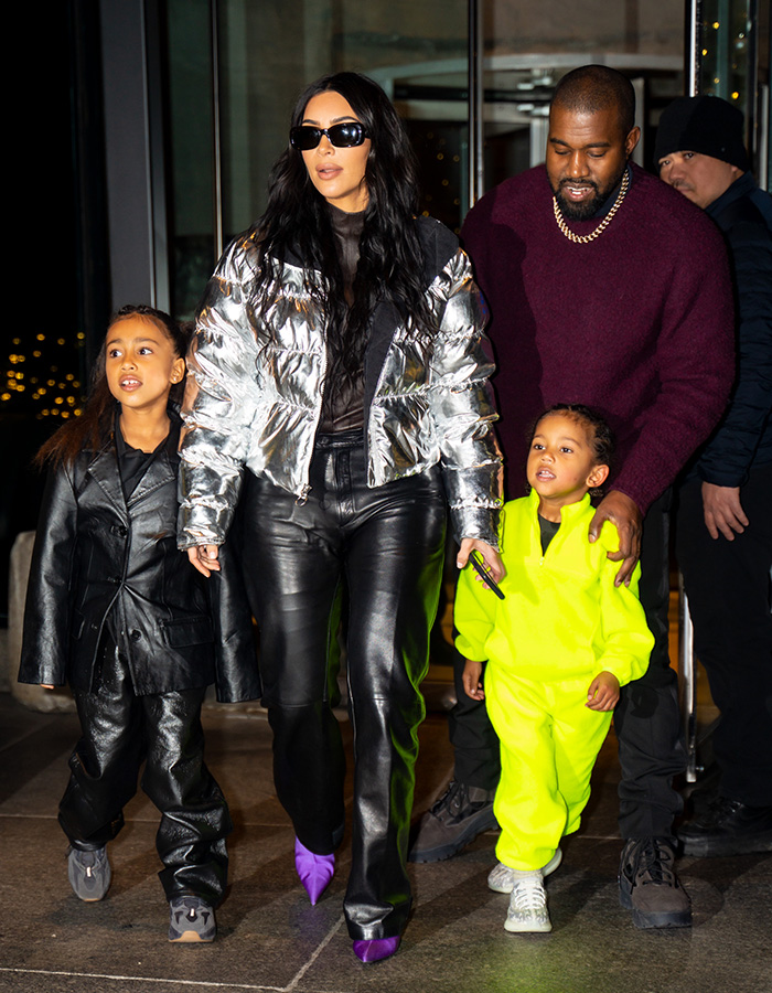 Kim Kardashian in a silver jacket with Kanye West and two of their 4 kids walking outside Kim Kardashian in a silver jacket with Kanye West and two of their 4 kids walking outside