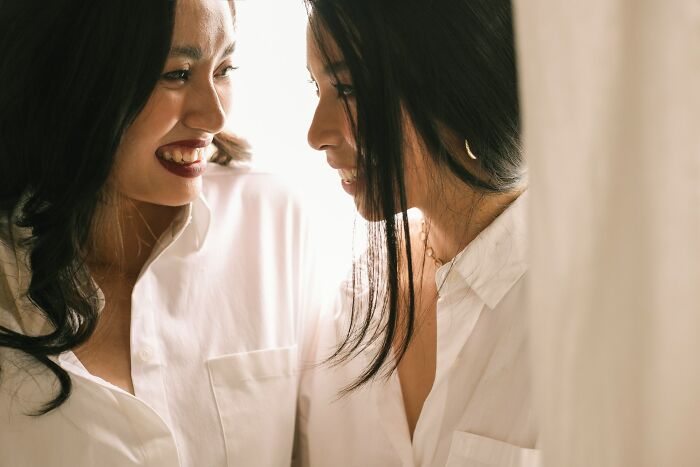 Two women smiling closely together, representing positive connections women refuse to tolerate losing
