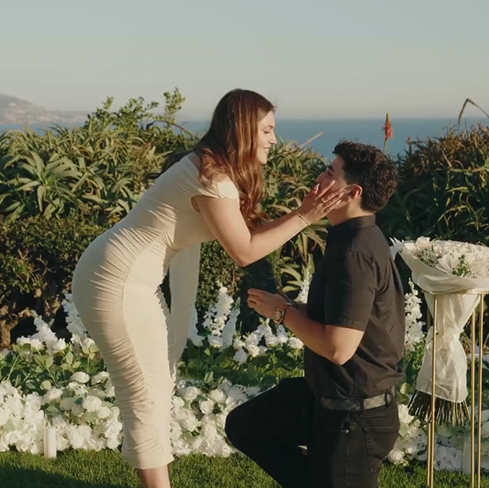 A romantic proposal in Laguna Beach with a man kneeling in front of his partner A romantic proposal in Laguna Beach with a man kneeling in front of his partner