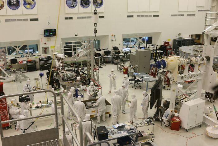 Scientists in a cleanroom laboratory, researching technologies related to non-human intelligence Scientists in a cleanroom laboratory, researching technologies related to non-human intelligence