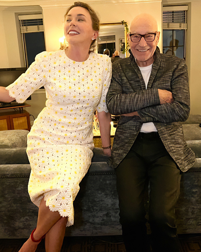 Actor Patrick Stewart smiling next to his wife Sunny Ozell indoors.