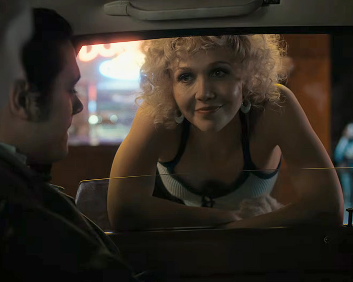 Hollywood actress leaning into a car window during filming of intimate scenes.