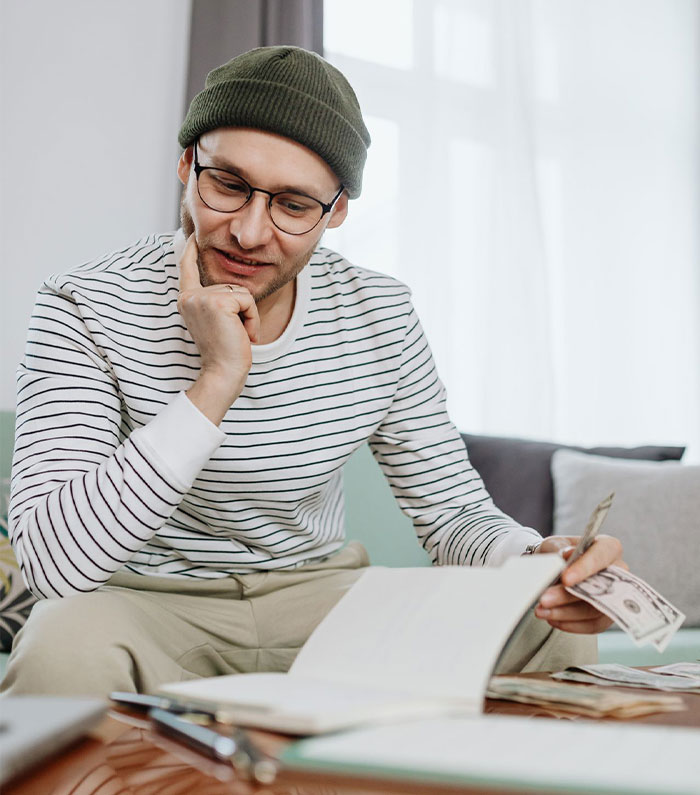 Man in striped shirt budgeting money using avalanche method