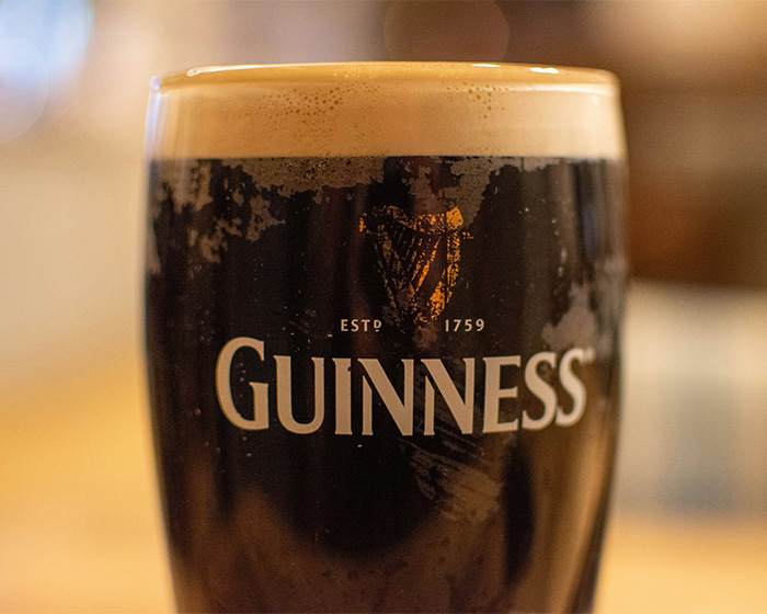 Close-up shot of a freshly poured glass of Guinness stout beer. Close-up shot of a freshly poured glass of Guinness stout beer.