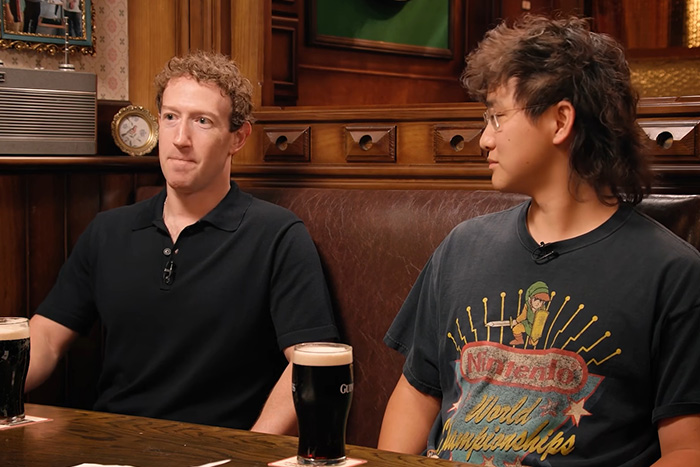 Mark Zuckerberg displaying bizarre behavior next to a friend while sitting at a table with glasses of Guinness. Mark Zuckerberg displaying bizarre behavior next to a friend while sitting at a table with glasses of Guinness.