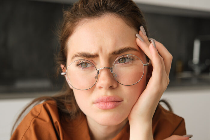 Worried woman wearing glasses thinking about husband obsession and marriage issues Worried woman wearing glasses thinking about husband obsession and marriage issues