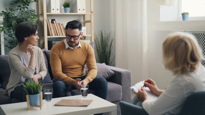 Couple having counseling session about husband's obsession Couple having counseling session about husband's obsession