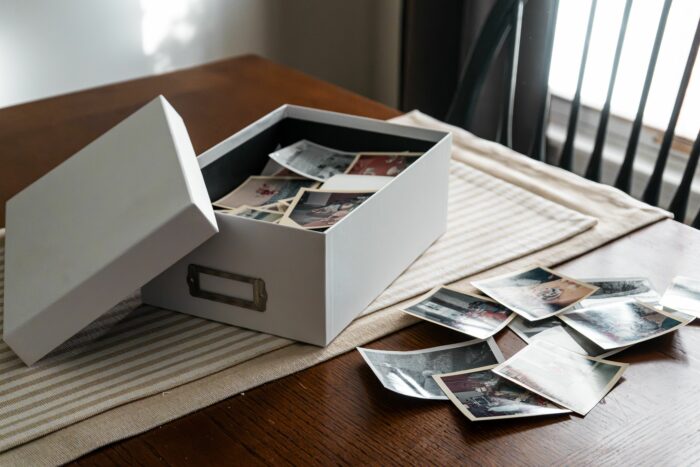 Box of photos spilling on table linked to husband's secret obsession Box of photos spilling on table linked to husband's secret obsession