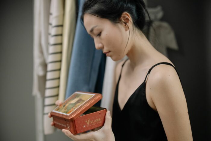 Woman holding a box revealing husband's hidden secret past obsession Woman holding a box revealing husband's hidden secret past obsession