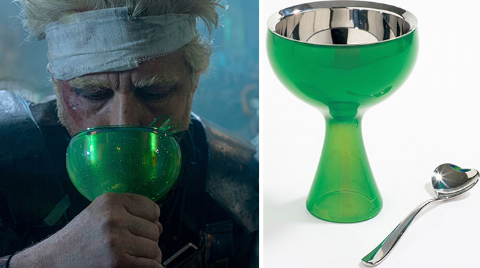 A character drinks from a green glass cup used as a creative movie prop in a sci-fi film.