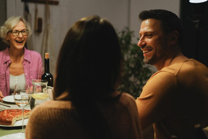 Family dinner scene with a happy MIL and DIL discussing name confusion over food. Family dinner scene with a happy MIL and DIL discussing name confusion over food.