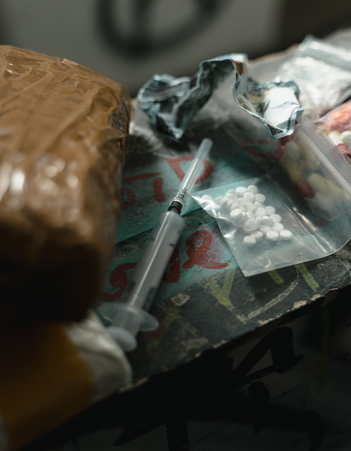 Close-up of d***s and syringe representing d**g a***e related to FIT student's d***h