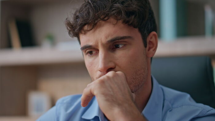 A worried man thinking deeply about advice for divorced people before marriage.