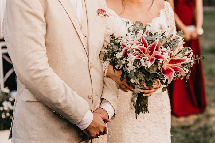 A bride holding a bouquet next to the groom, symbolizing a wedding ceremony and marriage advice.