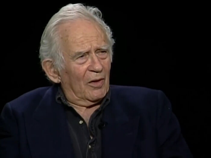 An older man speaking thoughtfully, representing the delivery of intelligent insults.