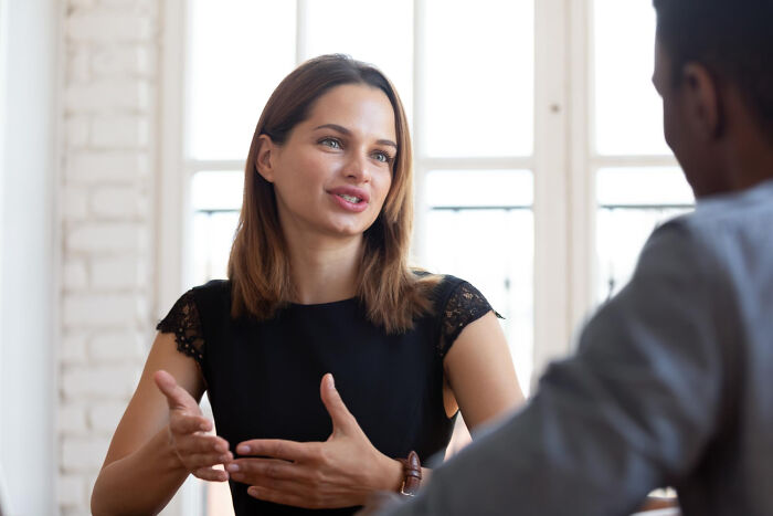 A woman explaining something with hand gestures, illustrating intelligent insults in conversation