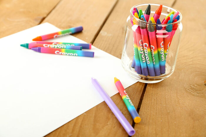 Colorful crayons in a jar and on paper, symbolizing intelligent insults with colorful meanings