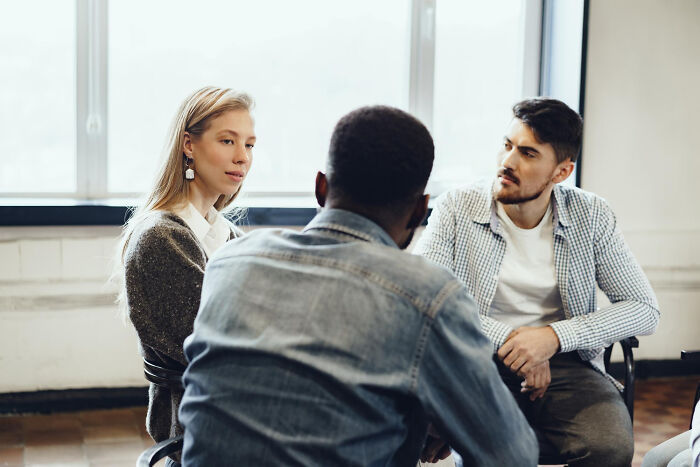 Three friends having an intense conversation, highlighting the social dynamics of intelligent insults.