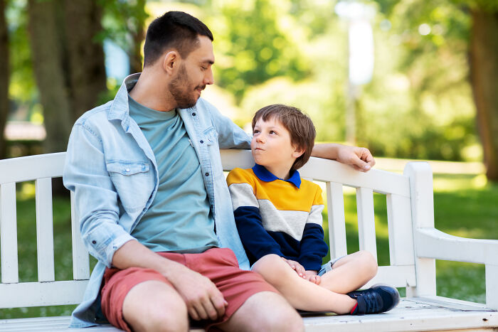 A father talking to his young son outdoors, representing dynamics with narcissistic parents.
