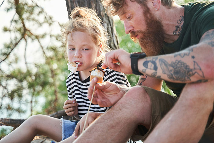 A father and daughter enjoying s'mores outdoors as a guy keeps pursuing ex in this family story update.