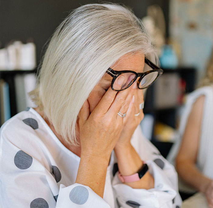 Distressed woman covering face as sister helps ex cross boundary