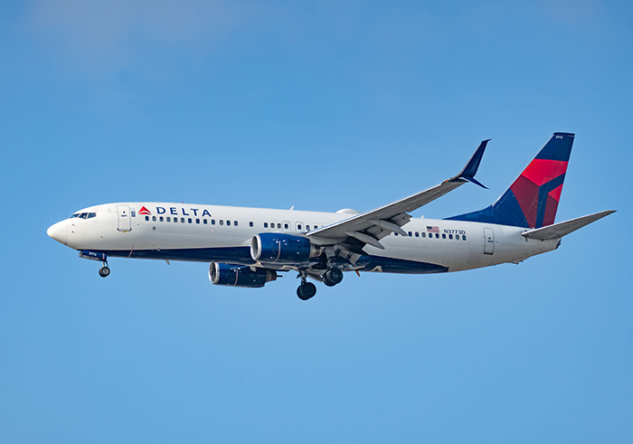 A Delta passenger plane flying in a clear blue sky. A Delta passenger plane flying in a clear blue sky.