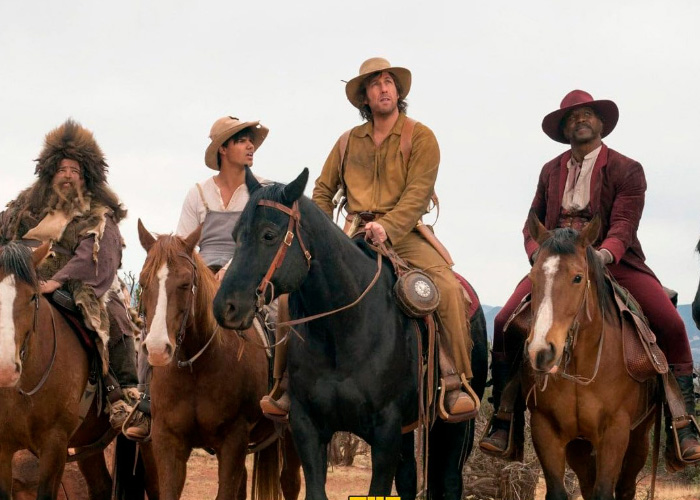 Adam Sandler riding a horse with cast members in a Western movie scene