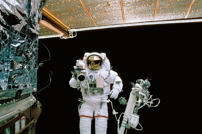 Astronaut floating in space with camera equipment, studying strange objects in our skies Astronaut floating in space with camera equipment, studying strange objects in our skies