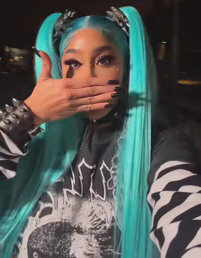 Natalie Nunn wearing bright blue hair pigtails and a studded bracelet for her Halloween transformation