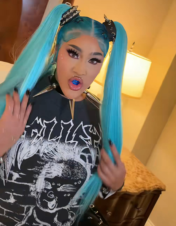 Natalie Nunn posing in a graphic tee with vibrant blue hair for Halloween transformation