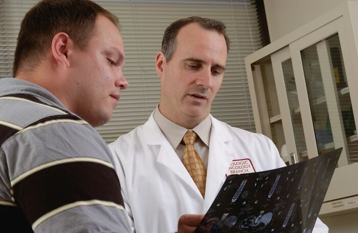 A doctor reviewing medical scans with a patient, reminiscent of difficult moments in cruel infidelity stories.