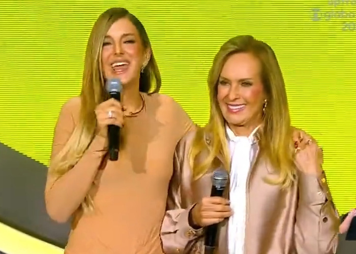 Two smiling women holding microphones on Nepo Babies show stage Two smiling women holding microphones on Nepo Babies show stage