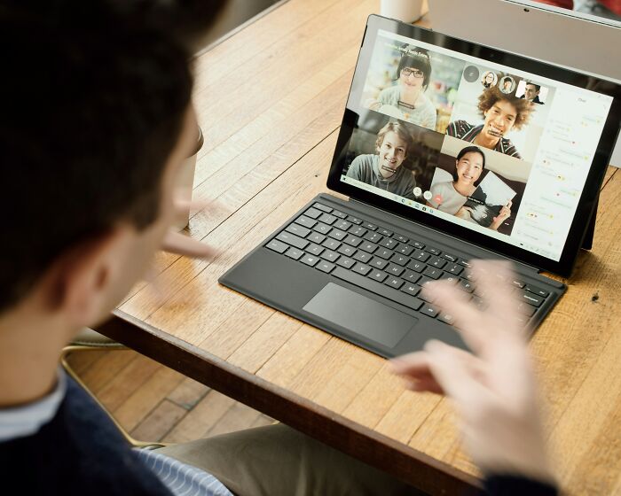 Person video chatting on a laptop tablet, sharing drama in tiny communities