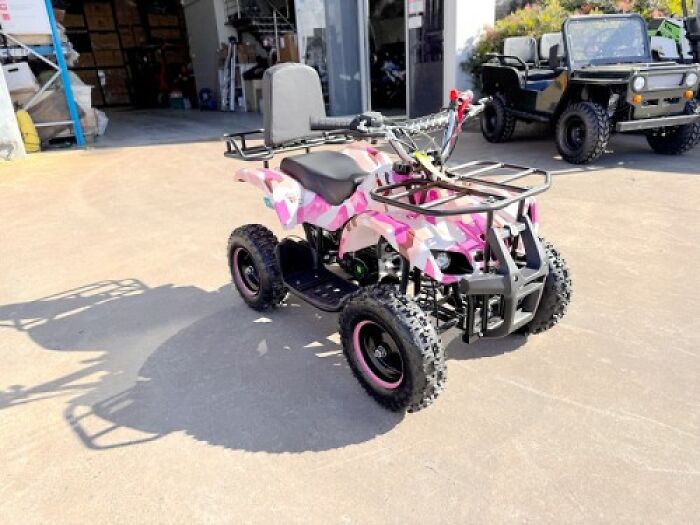 A pink camouflage quad bike parked outdoors in a tiny community setting.