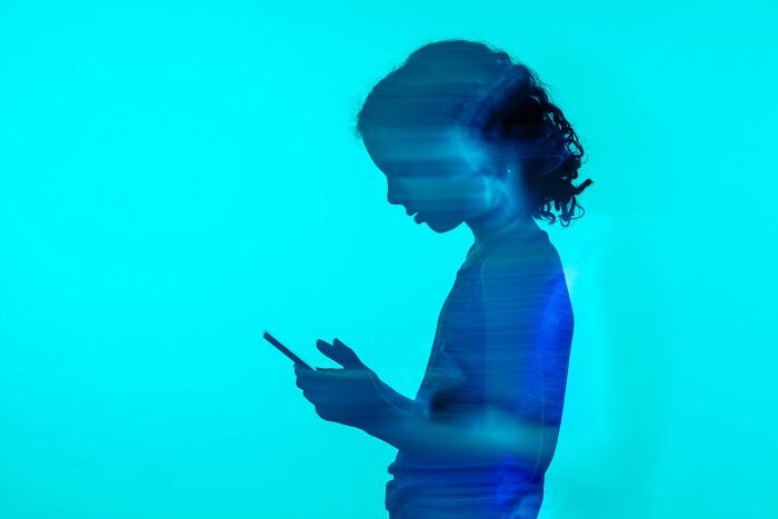 A silhouette of a child looking at a smartphone, representing mental health problems in Gen Z.