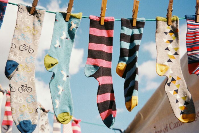 Colorful patterned socks hanging on clothesline outdoors