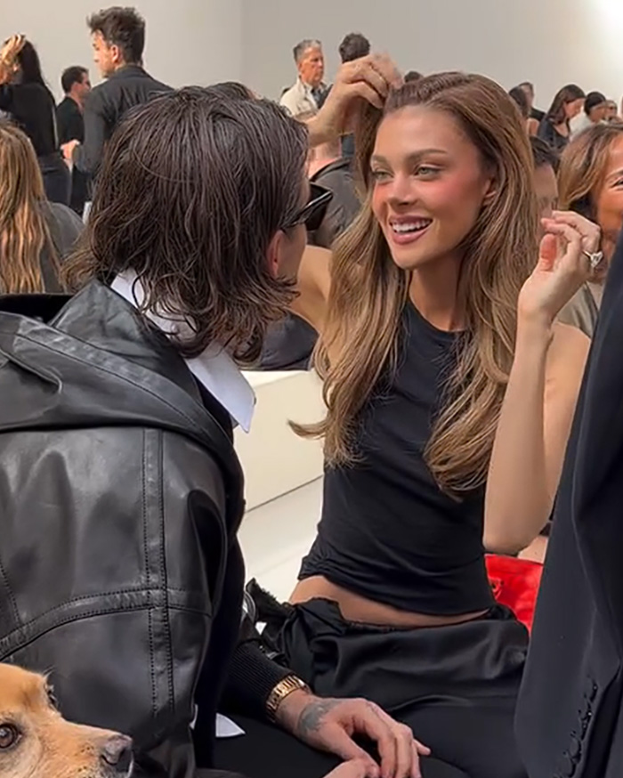 Nicola Peltz adjusts her hair while talking with Brooklyn Beckham in a viral video clip